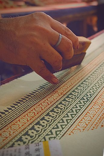 Artisan in Jaipur hand-printing fabric using traditional wooden blocks, showcasing the city’s centuries-old block printing craft