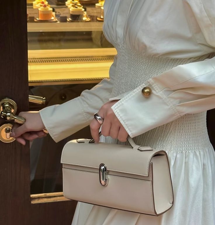 Close-up of the Savette Symmetry Pochette in a woman’s hand, emphasizing its refined craftsmanship and elegant proportions