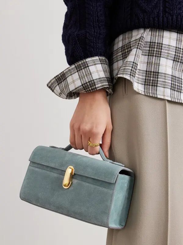 Close-up of the Savette Symmetry Pochette in a woman’s hand, emphasizing its refined craftsmanship and elegant proportions